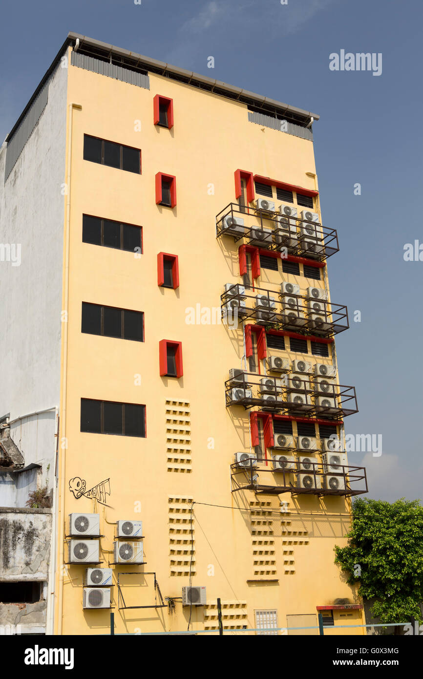 Klimatisierte Gebäude in den Tropen. Wand voller Air con auf eine gelbe Wand eines Hochhauses. Stockfoto