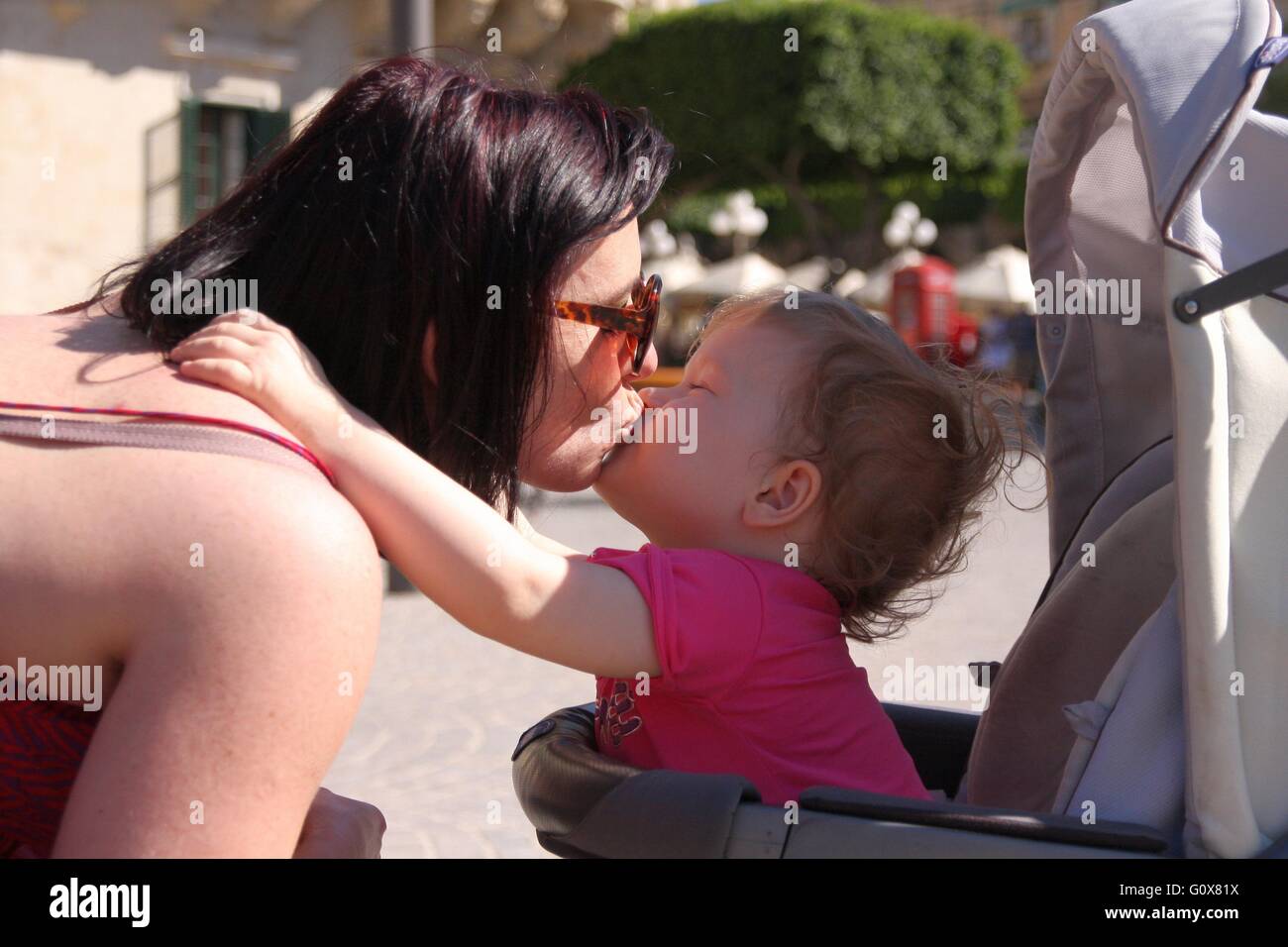 Kleines Mädchen küsst ihre Mama Stockfoto