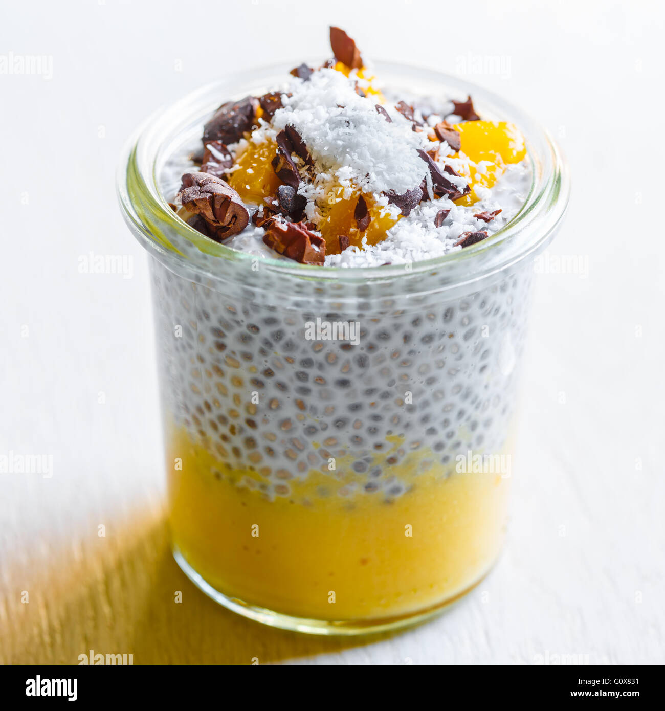 Chia-Kokos-Pudding mit Mango-Mousse und Kakao-nibs Stockfoto