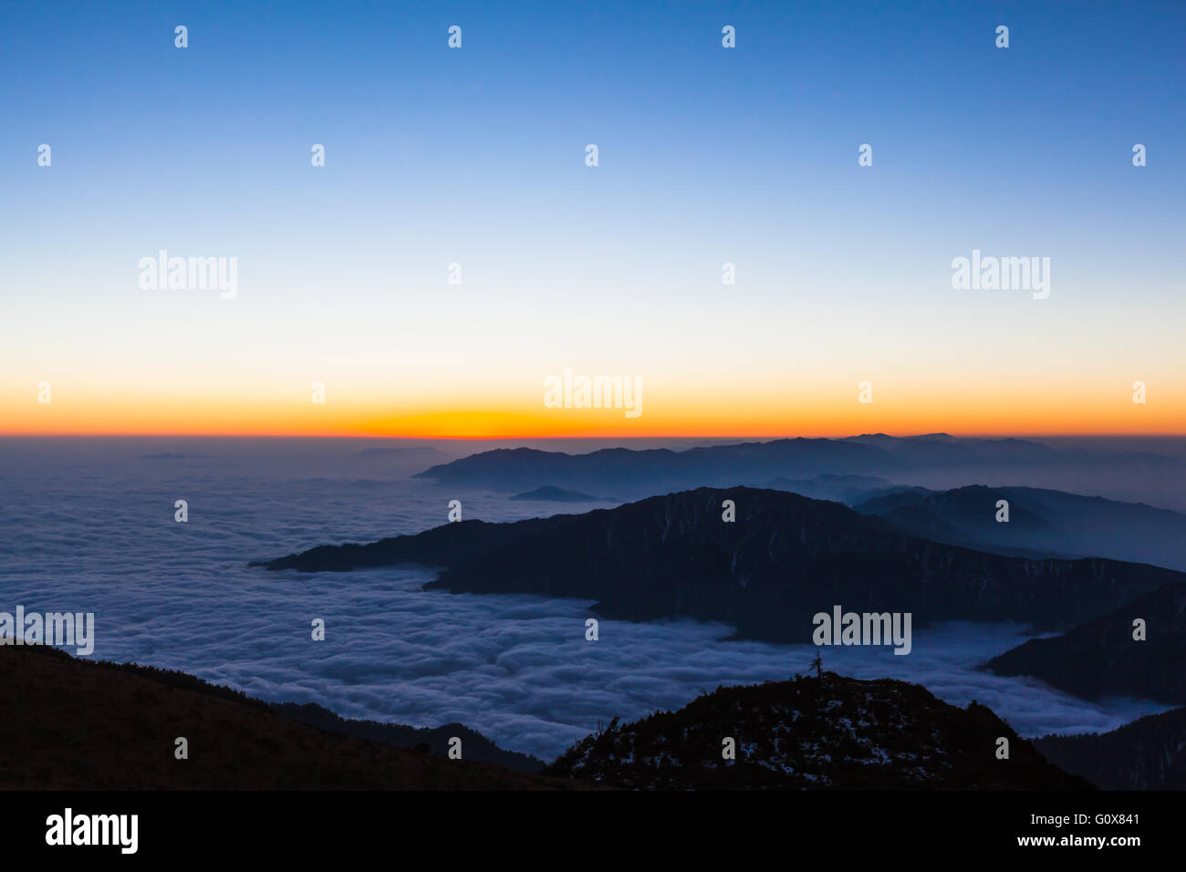 Atemberaubende Aussicht auf den Sonnenaufgang mit Silhouette der Berge und herrliche Wolkengebilde auf Rinder zurück Berg (Niubeishan) Stockfoto