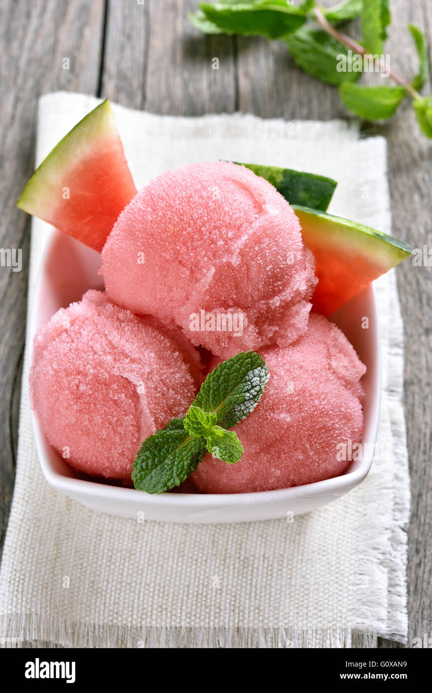 Wassermelone-Sorbet-Eis in Schüssel auf hölzernen Hintergrund Stockfoto