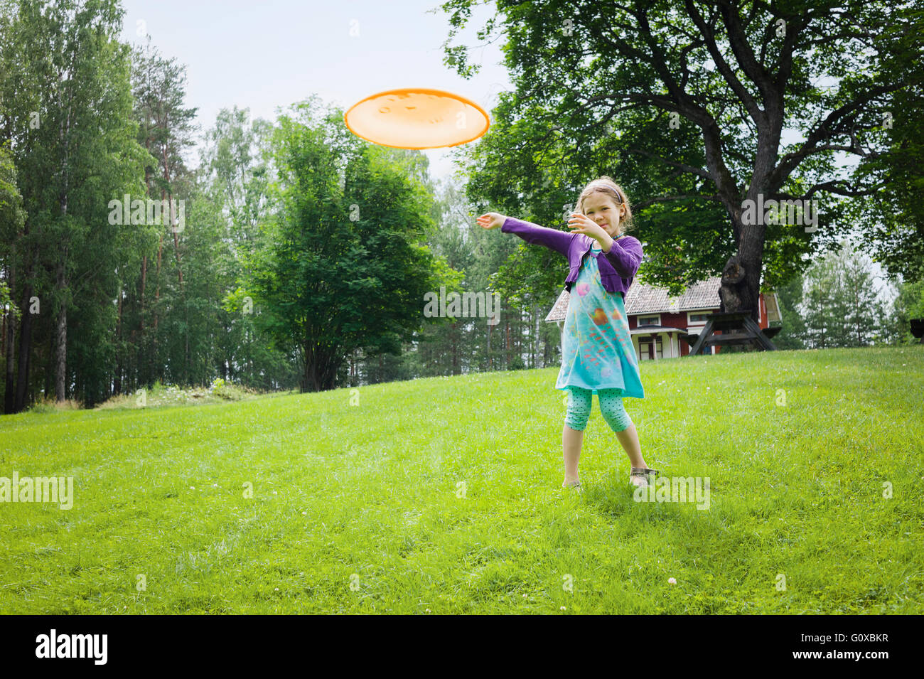 Junge Mädchen spielen mit einer Frisbee im Garten, Schweden Stockfoto