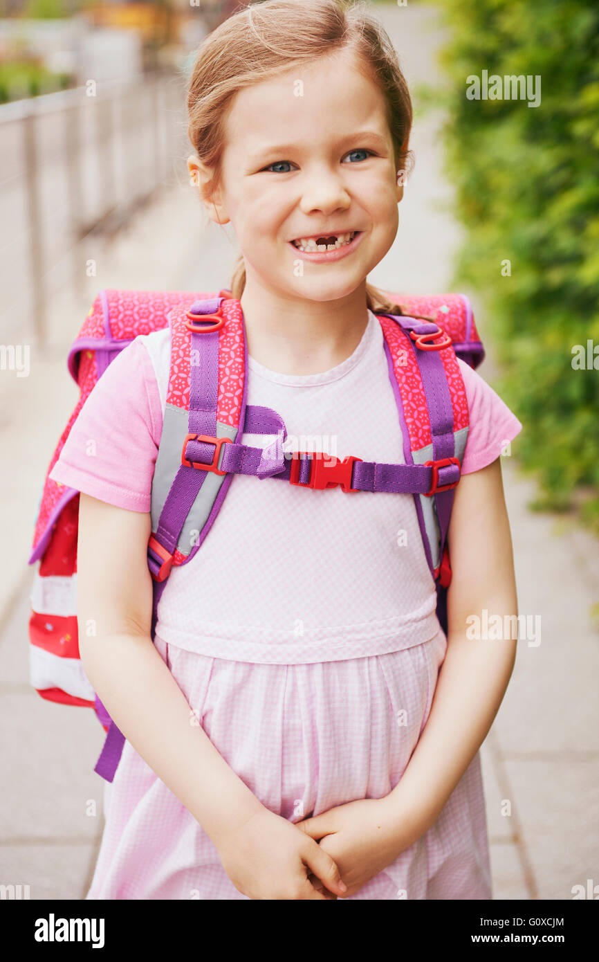 5 Jahre alte Schülerin mit rosa Schulranzen mit fehlenden Zähnen lächelnd Stockfoto