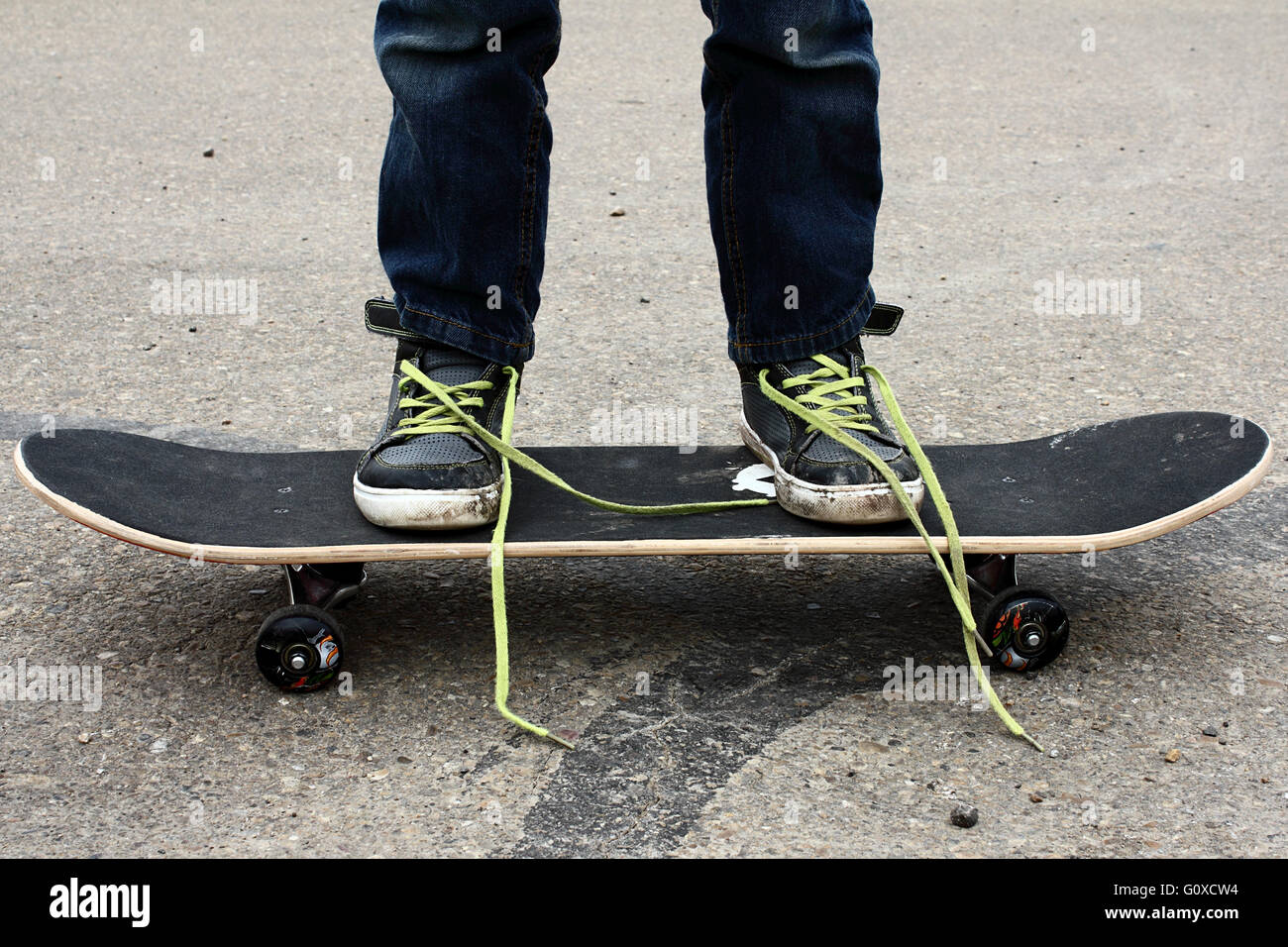 Ein Junge auf einem Skateboard mit seinen Schnürsenkeln gelöst. Stockfoto