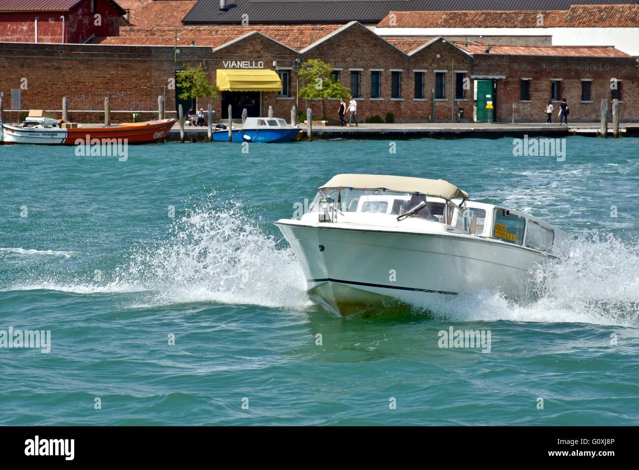 Ein kleines Boot Fahrt durch den Kanal in Venedig Stockfoto