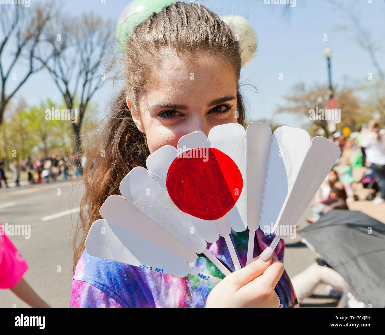 Kaukasische Mädchen für Gesicht mit Japanpapier Lüfter während 2016 National Cherry Blossom Festival - Washington, DC USA Stockfoto