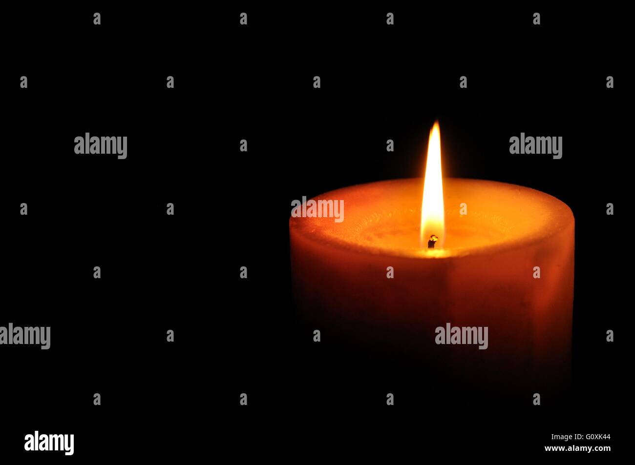 Kerze auf der rechten Seite des Rahmens mit schwarzem Hintergrund Stockfoto