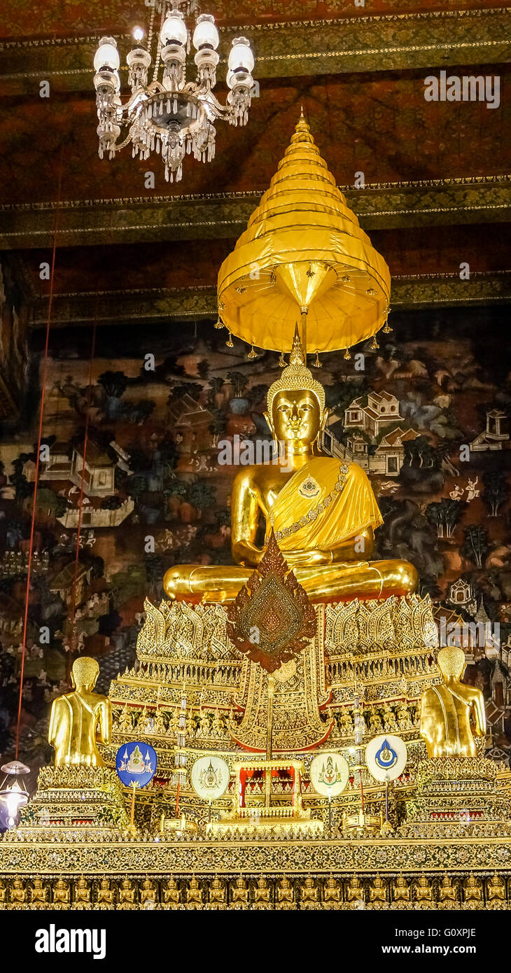 Altar mit goldenen Buddha. Buddha befindet sich in einem Tempel vor einer Wandmalerei Stockfoto