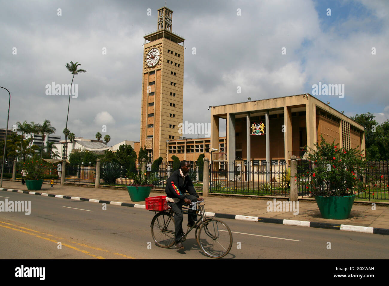 Kenianischen Mann Radfahren in im Zentrum von Nairobi, ein Fahrrad mit einer christlichen Kirche im Hintergrund Stockfoto