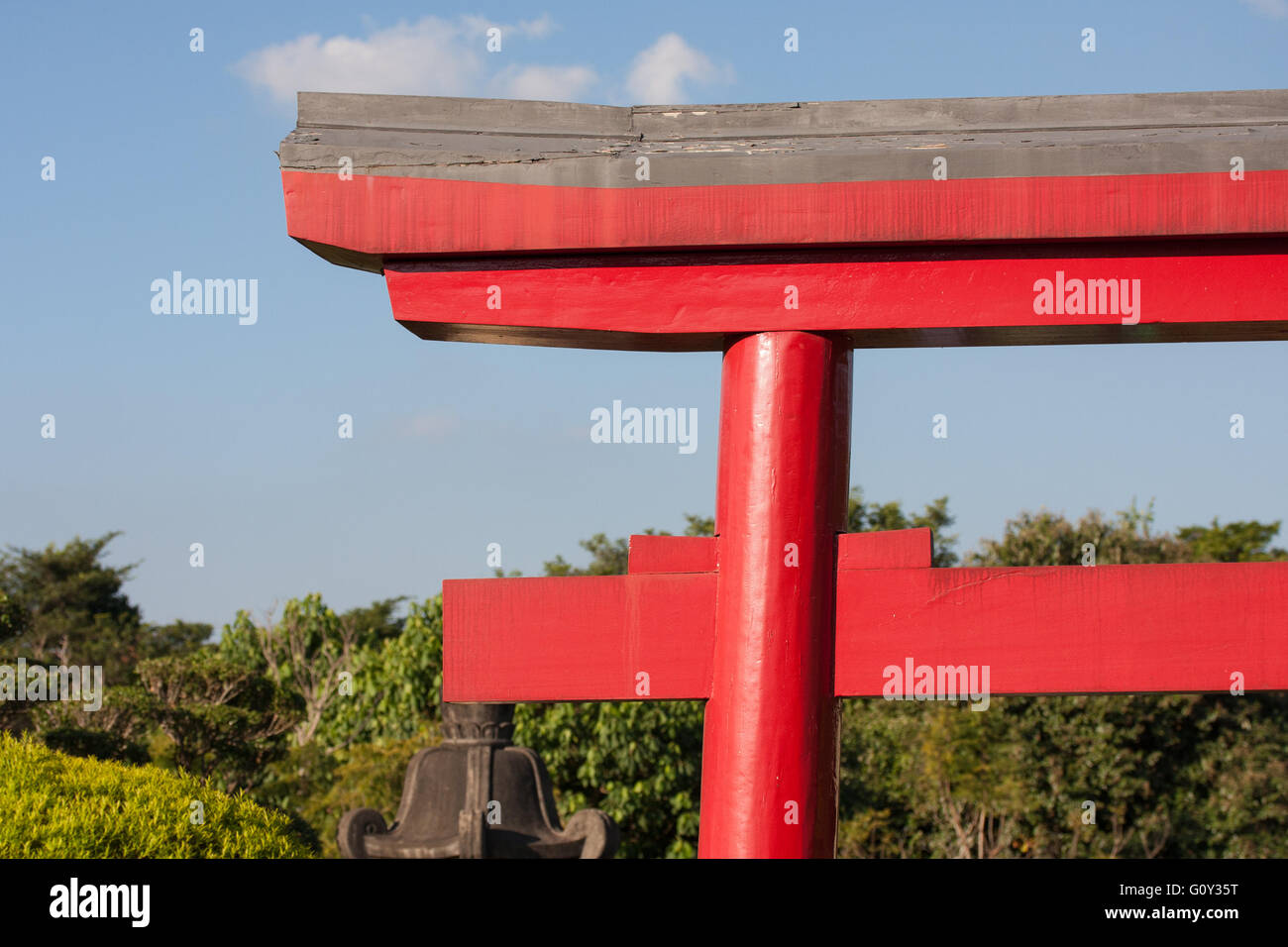 Roter japanischer Architektur mit Bäumen Himmel und Wolken hinter Stockfoto