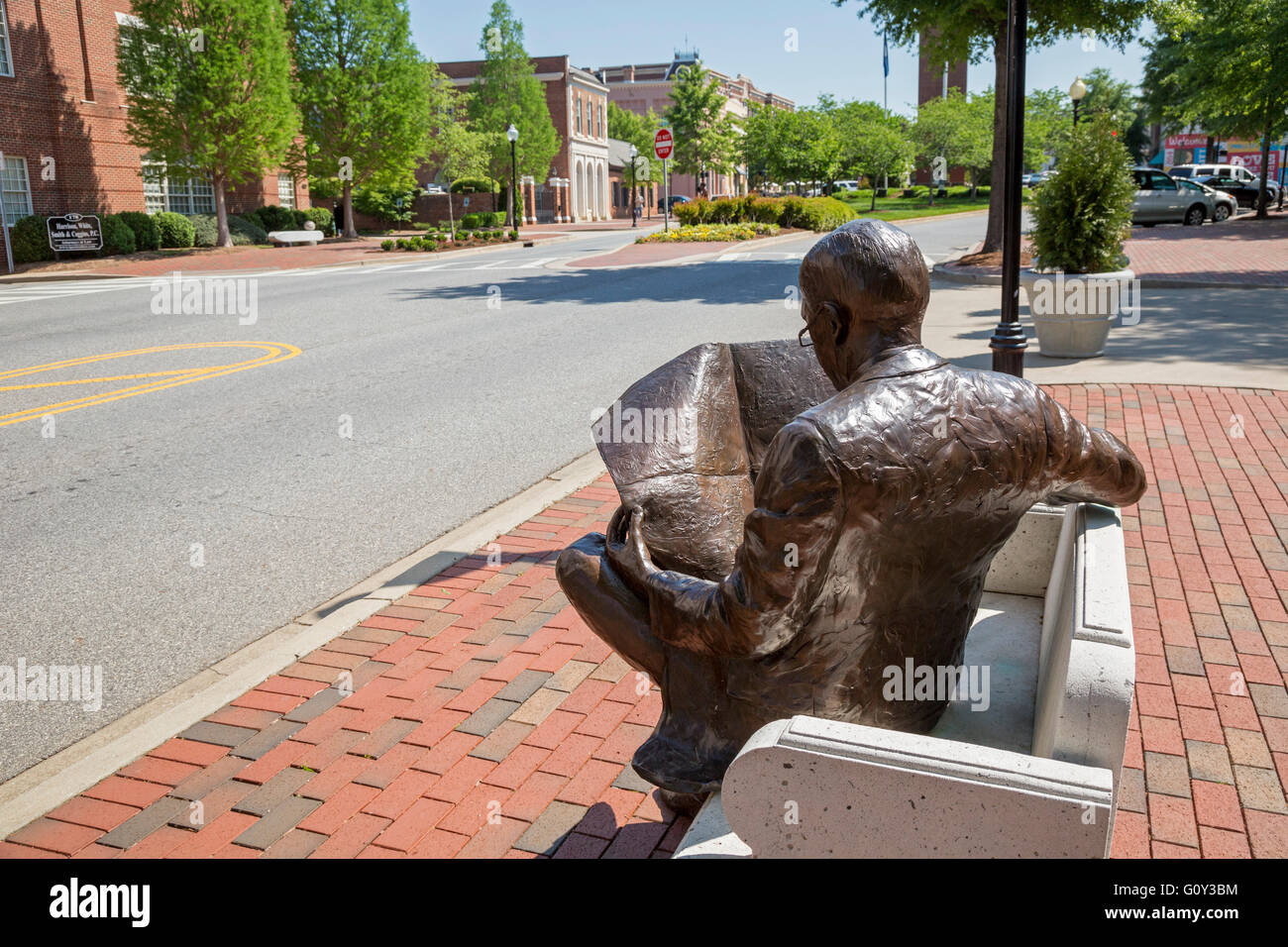 Spartanburg, South Carolina - eine Skulptur eines Mannes sitzen auf einer Bank und liest eine Zeitung außerhalb Spartanburg Herald-Journal Stockfoto