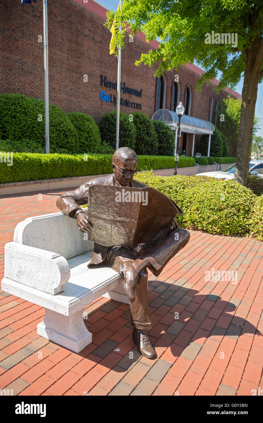 Spartanburg, South Carolina - eine Skulptur eines Mannes sitzen auf einer Bank und liest eine Zeitung außerhalb Spartanburg Herald-Journal Stockfoto