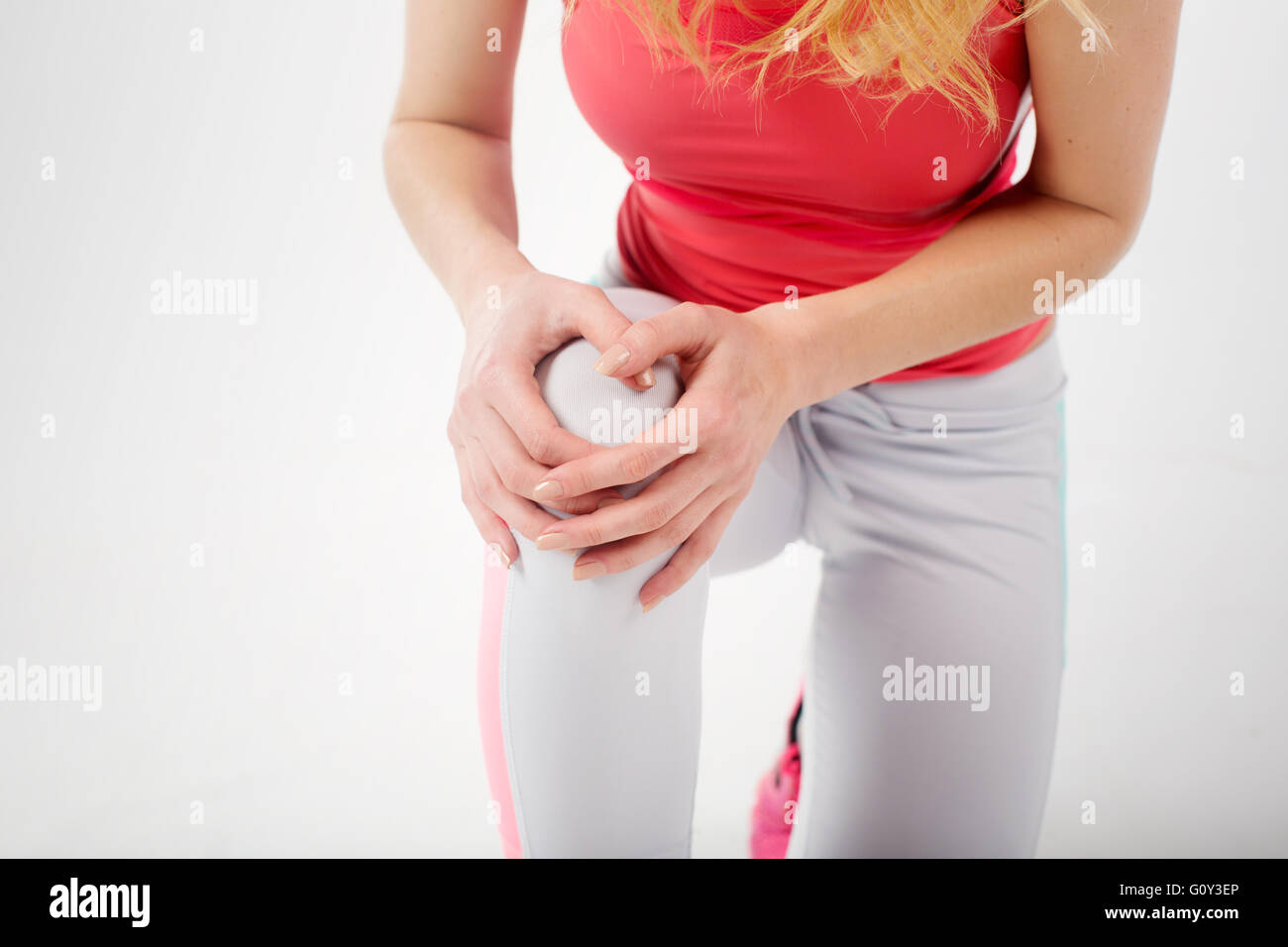 Nahaufnahme der Sportlerin in Fitnesskleidung holding Knie Schmerzen Stockfoto