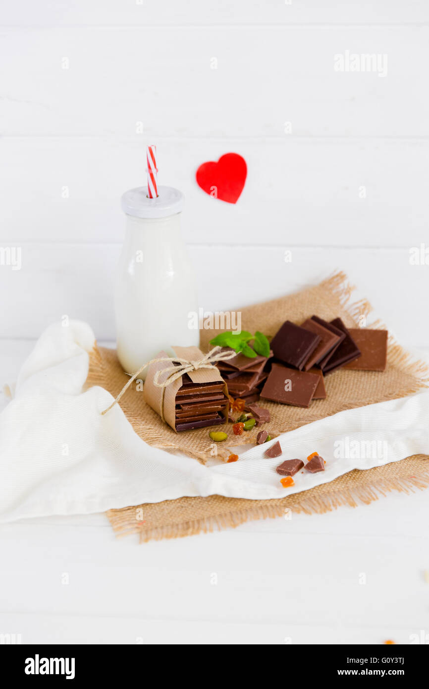 Milchflasche mit Stapeln von Schokolade Stockfoto