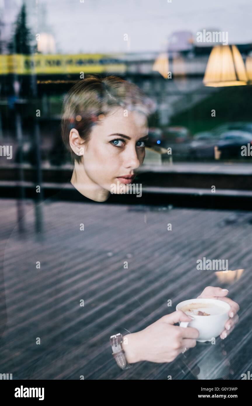 Frau, die im Café Kaffee trinkt Stockfoto