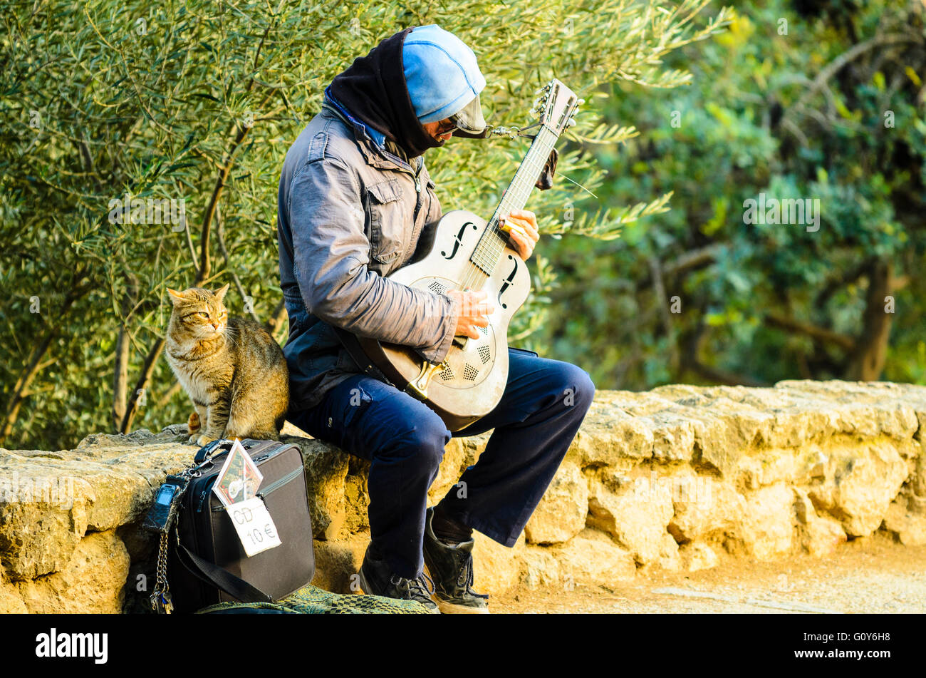 Straßenmusiker und Katze im Park Güell Barcelona Katalonien Spanien Stockfoto