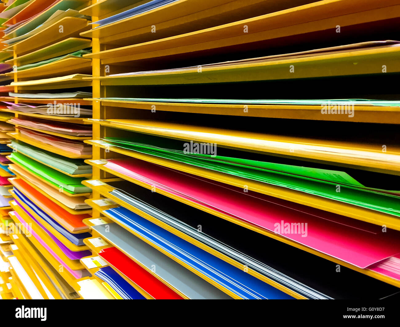 Papier in verschiedenen Farben in den Regalen angeordnet. Stockfoto