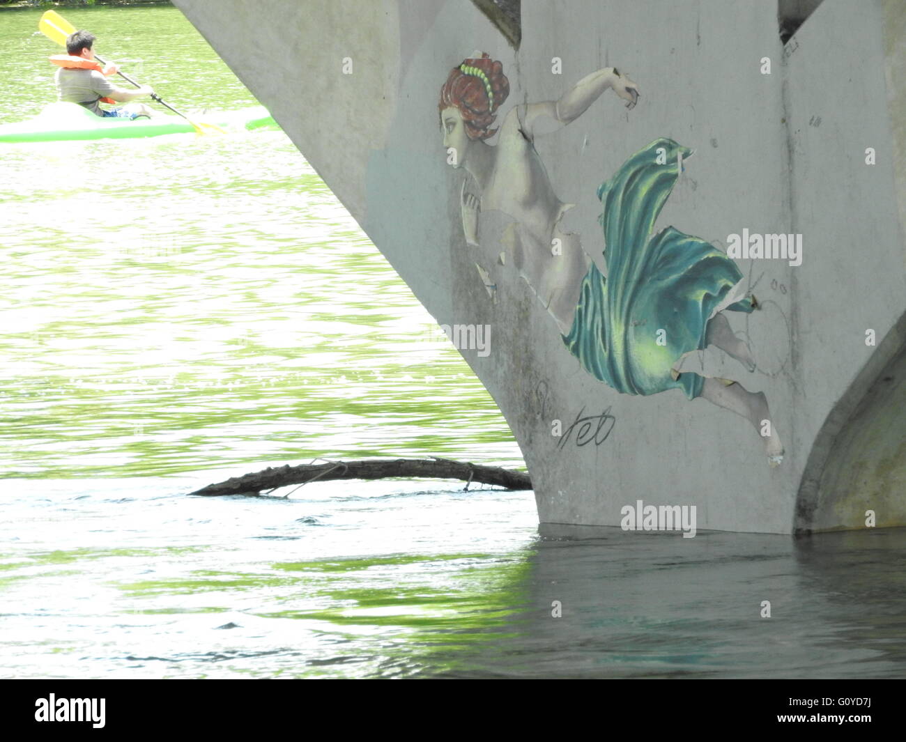 Eine Frau, dargestellt auf einer Brücke schaut ein Kajakfahrer. Stockfoto