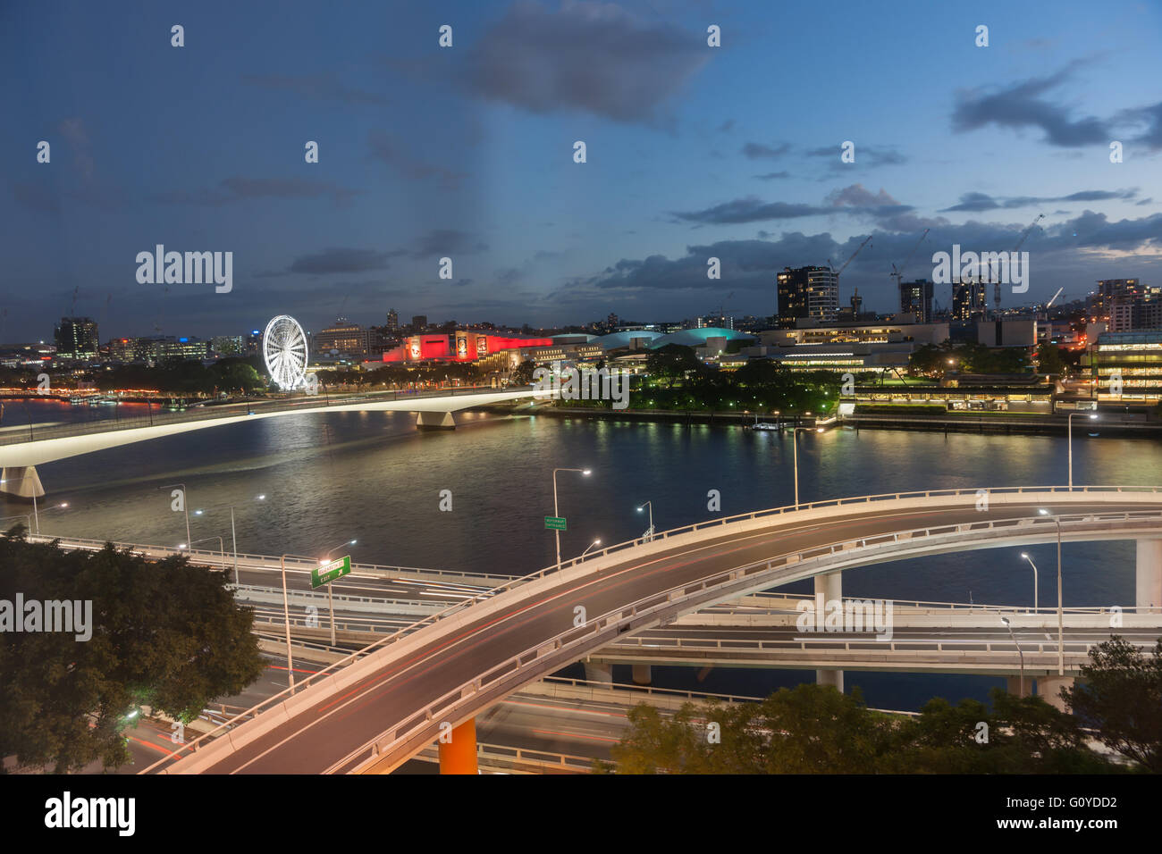 Brisbane Nachtlichter über gestaffelten Fahrbahnen Fluss und South Bank Gebäude und Riesenrad Stockfoto