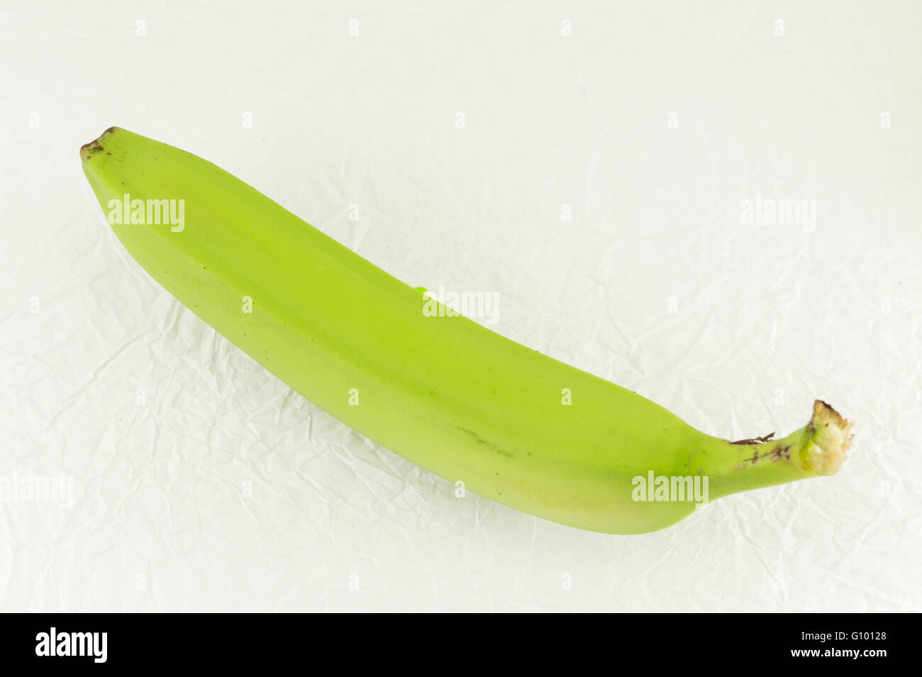 Grünen jungen Bananen auf weißen Textilien Stockfoto