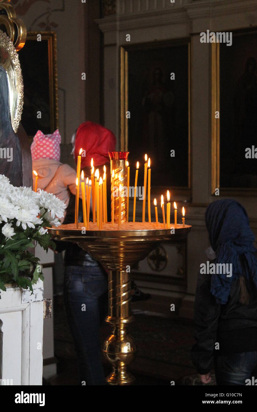 goldenen Leuchter brennen Kerzen am sonntäglichen Gottesdienst in der orthodoxen Kirche voller Stockfoto