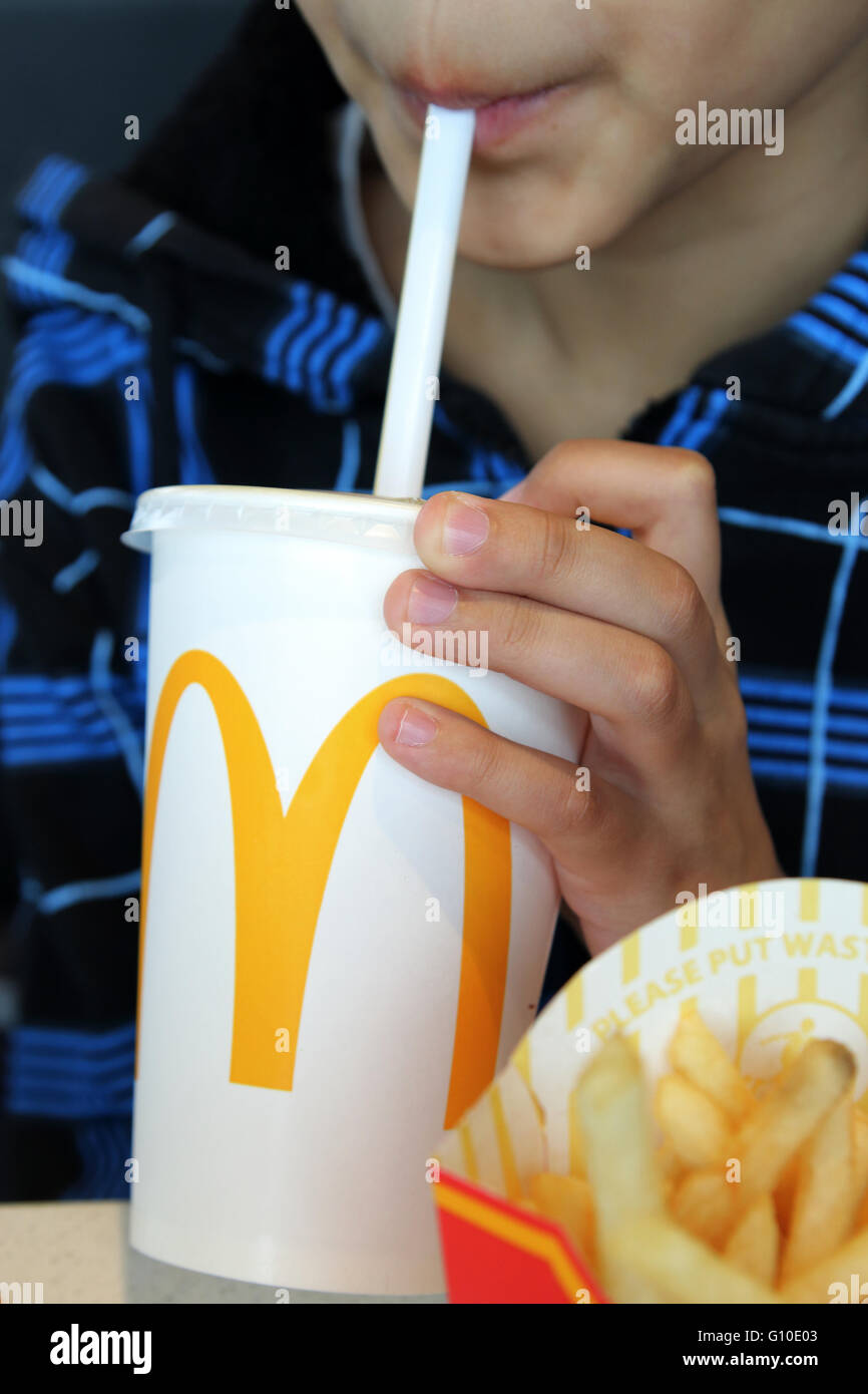 Ein Kind trinken Softdrink McDonald's - Nahaufnahme Stockfoto