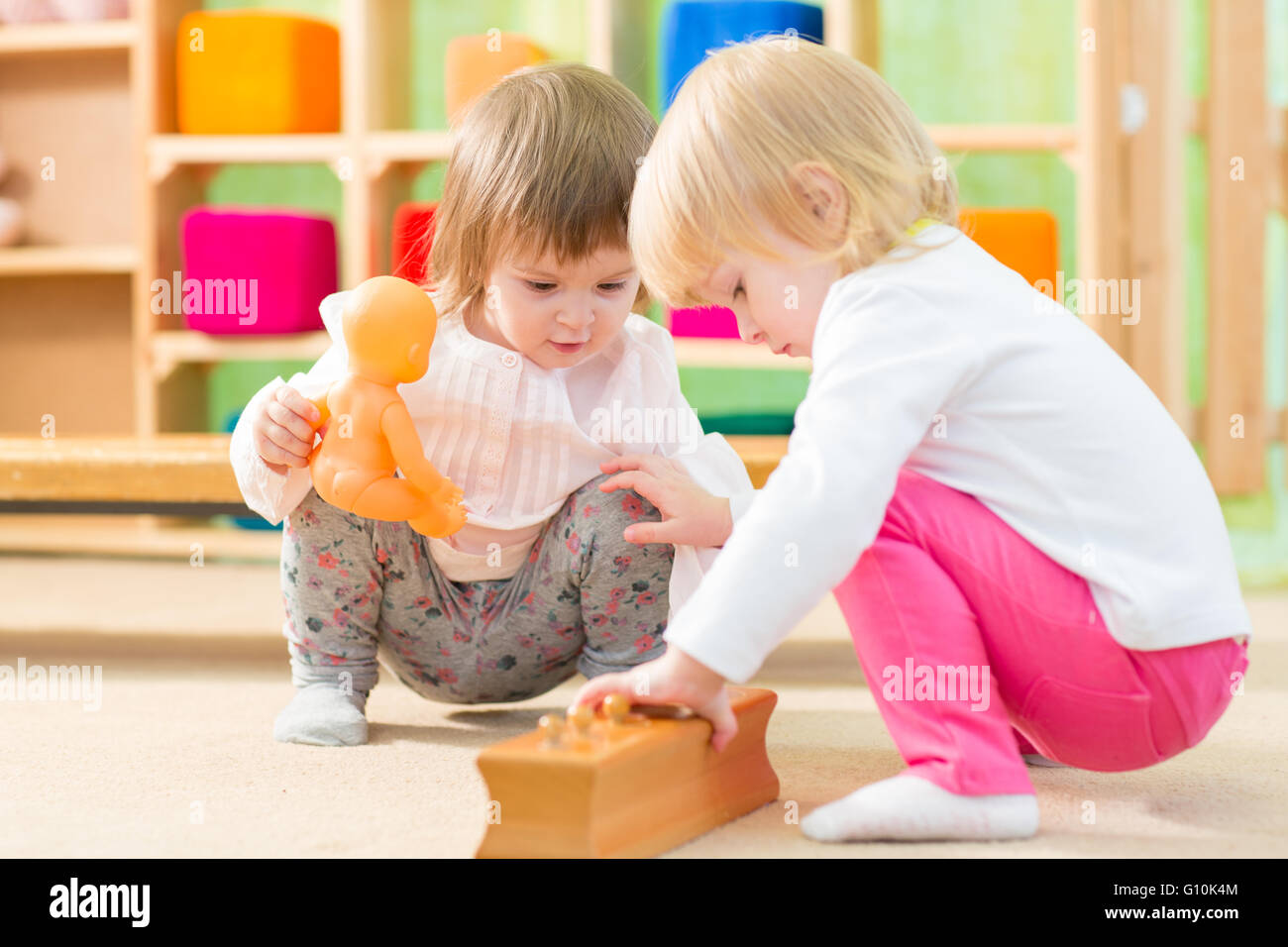 Nachdenkliche Kinder spielen im Kindergartenraum Stockfoto