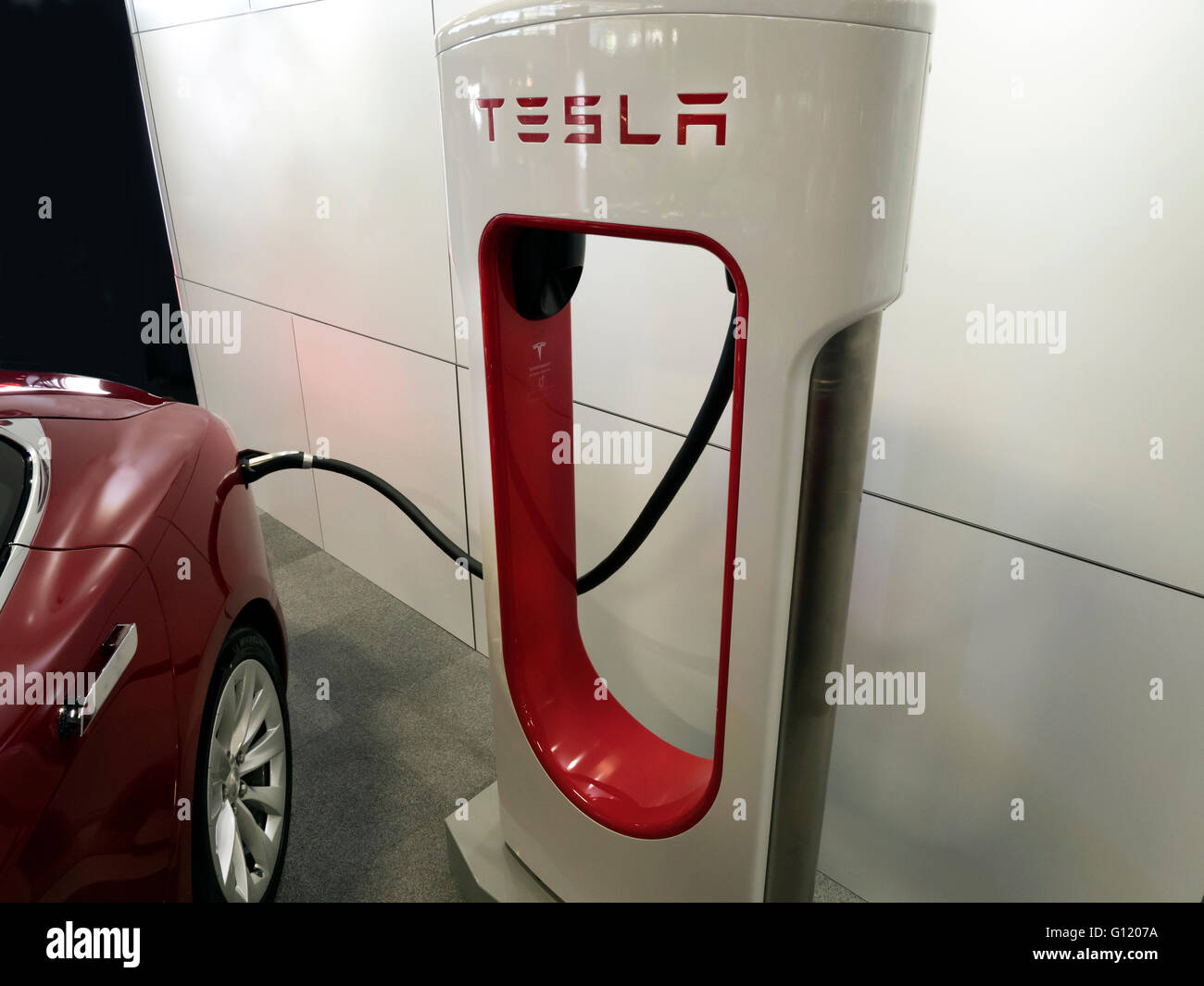 Tesla Elektroauto aufladen bei Tesla Ladestation Stockfoto