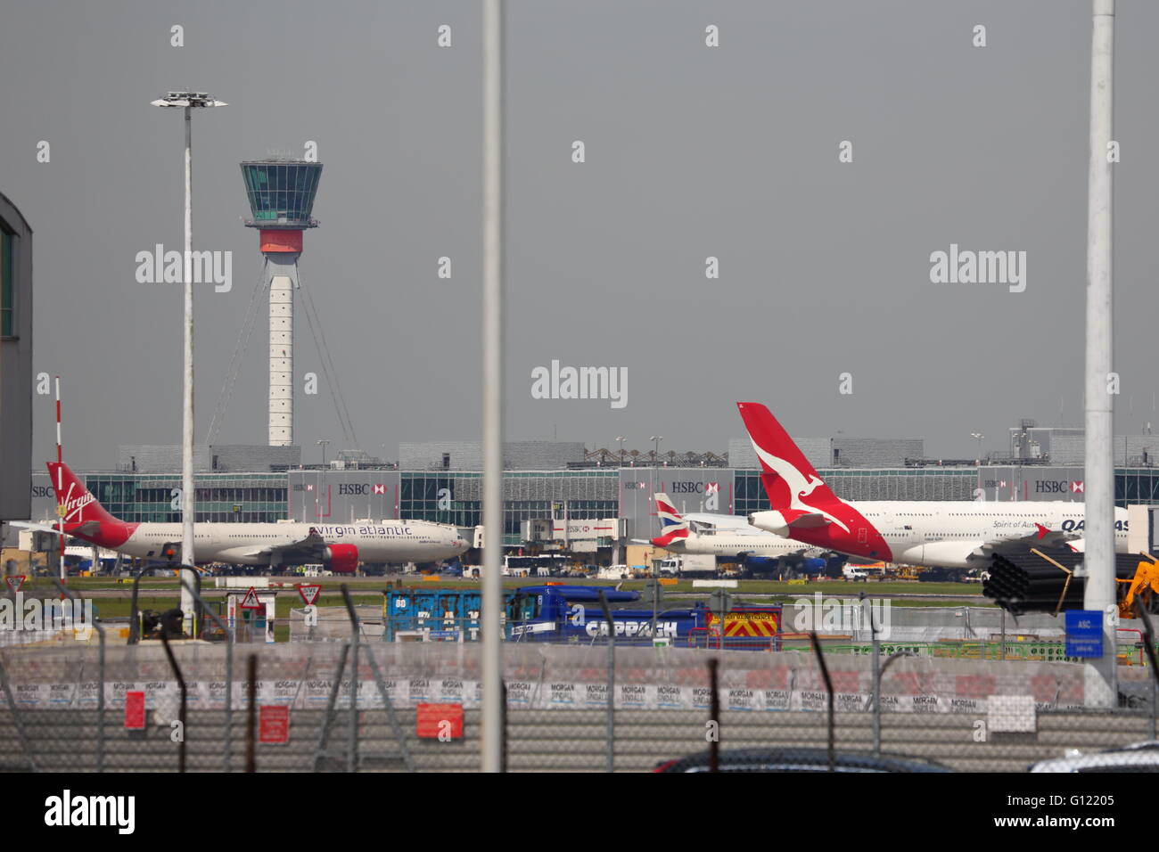 Beschäftigt der Flughafen London Heathrow mit Toren und Kontrollturm Stockfoto