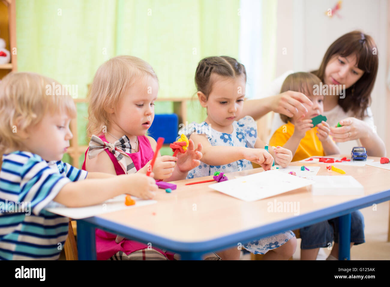 Kinder lernen Kunst und Kunsthandwerk im Kindergarten mit Lehrer Stockfoto