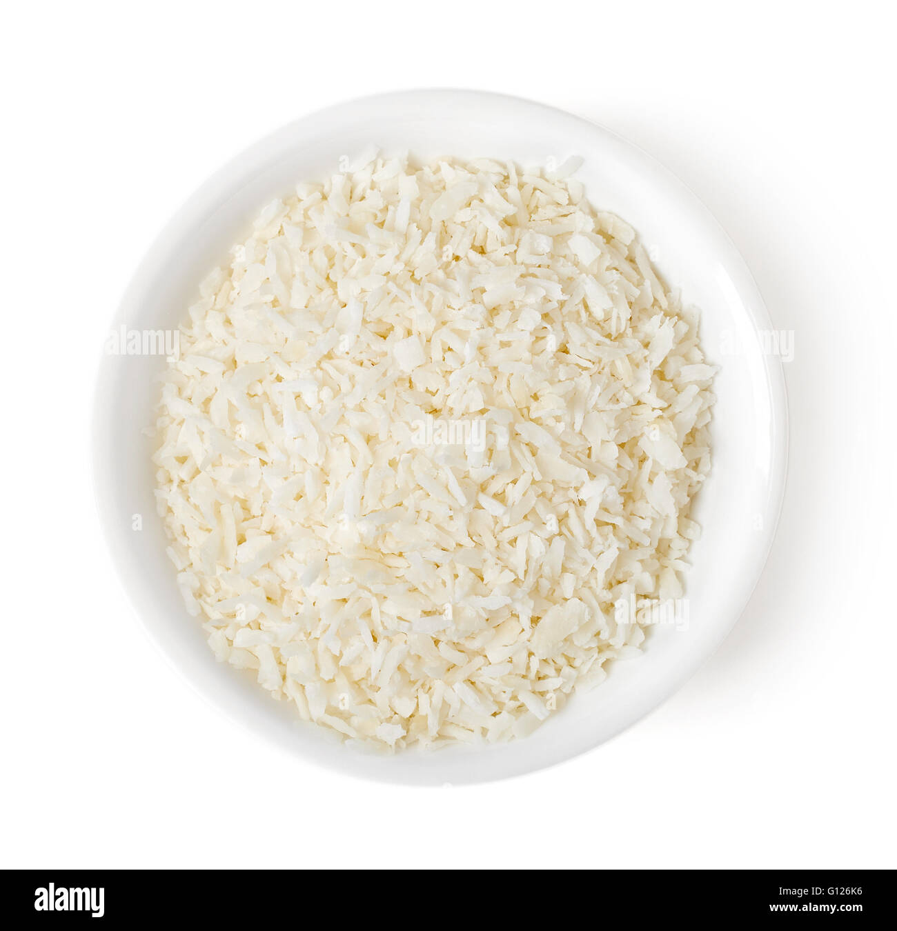 Schüssel mit Kokosraspeln isoliert auf weißem Hintergrund, Ansicht von oben Stockfoto