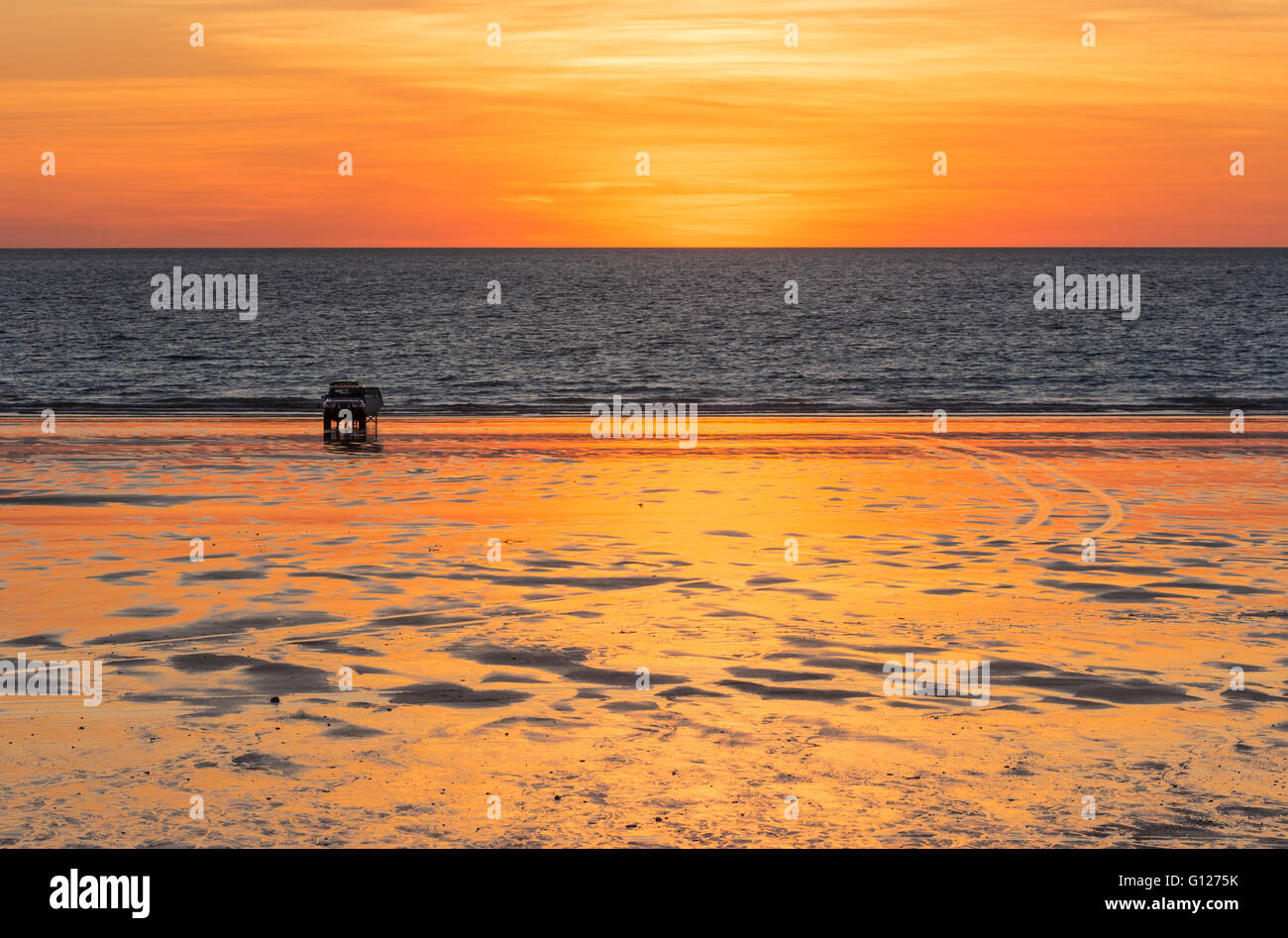 Ein Fahrzeug mit Allradantrieb mit seiner offenen Tür geparkt am Cable Beach bei Sonnenuntergang, Broome, Kimberley, Western Australia Stockfoto