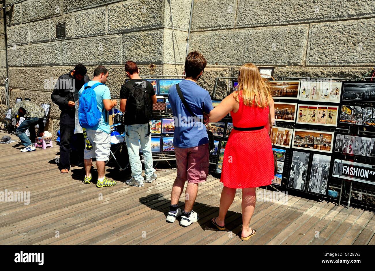 New York City: Touristen innehalten, um darüber nachzudenken, massenhaft produzierten Kunst verkauft von einem Anbieter neben der Westturm der Brooklyn Bridge Stockfoto