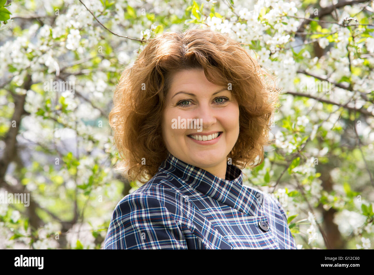 Porträt einer Frau mit lockigen Haaren im Frühlingspark Stockfoto