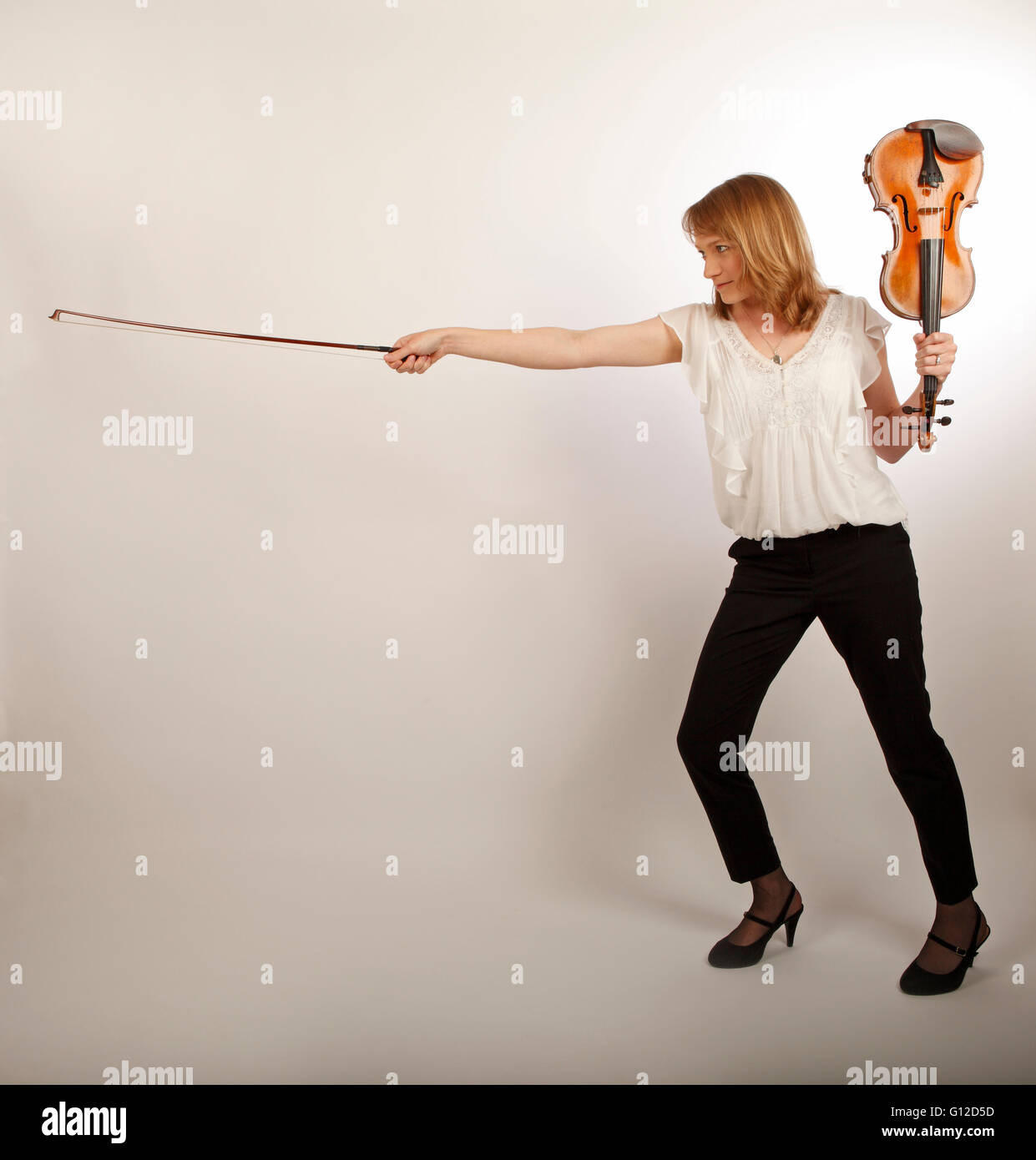 junge Frau mit Violine und Bogen wie ein Schwert und Schild Stockfoto junge Frau mit Violine und Bogen wie ein Schwert und Schild Stockfoto