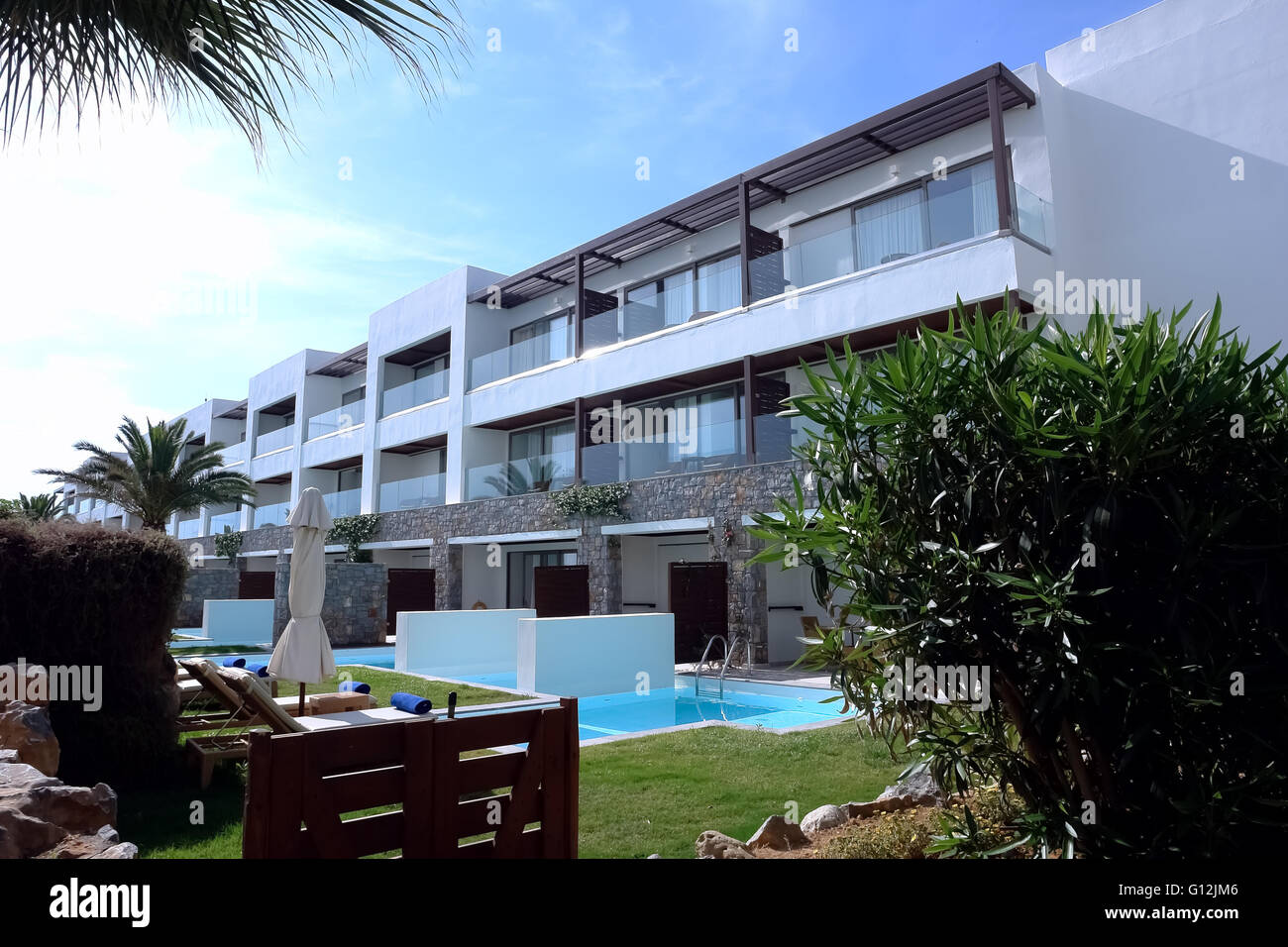 HERAKLION, Kreta, Griechenland - 13. Mai 2014: Der blaue Himmel, modernes Gebäude Villa mit Balkon, Pool und Palmen. Stockfoto
