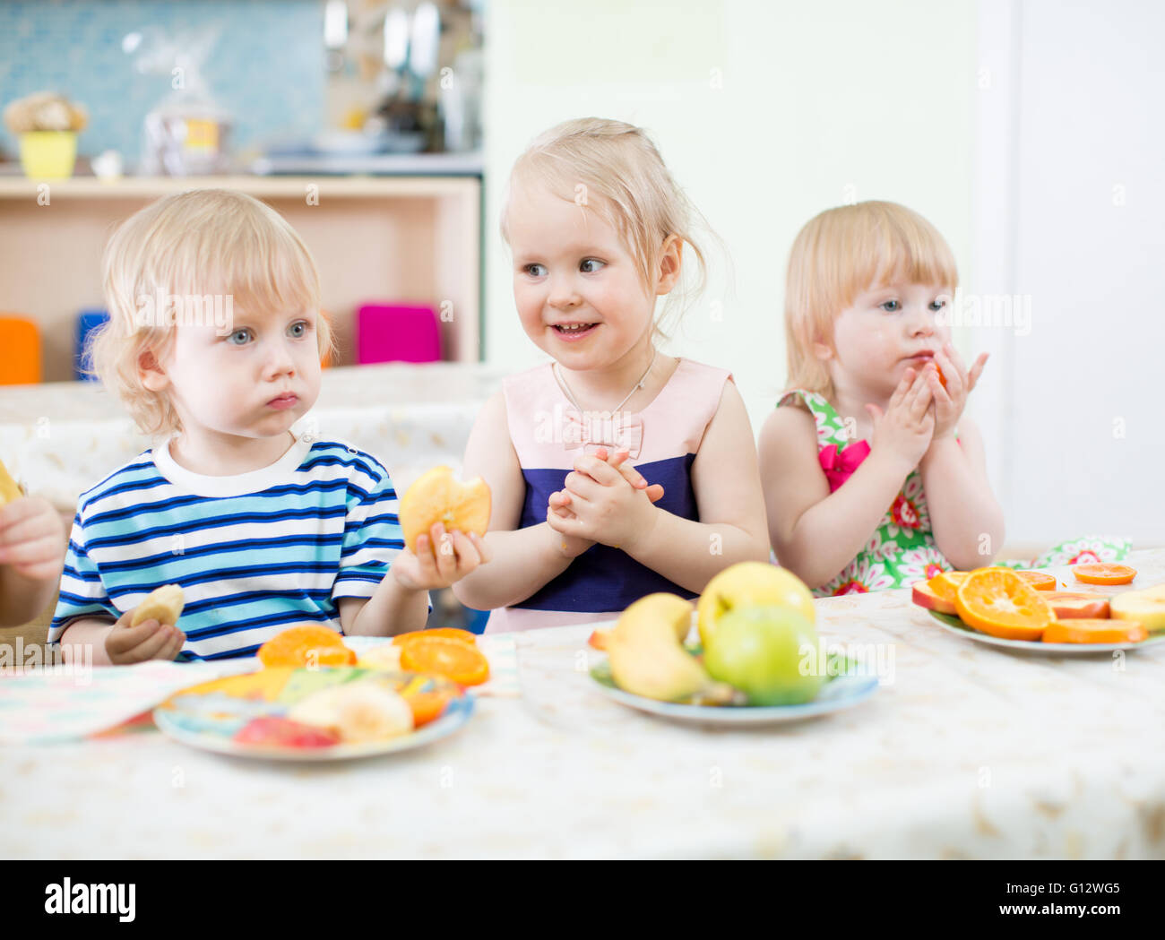 Kinder essen Obst im Kindergarten Speisesaal Stockfoto