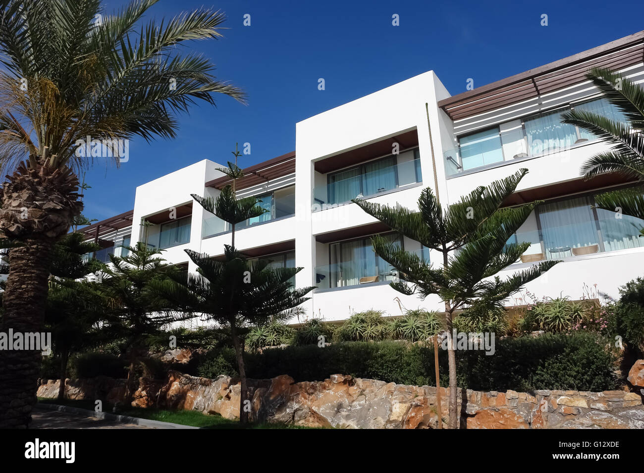 HERAKLION, Kreta, Griechenland - 13. Mai 2014: Der blaue Himmel, modernes Gebäude mit Balkonen und Palmen auf dem Gelände des Hotel Villa Stockfoto