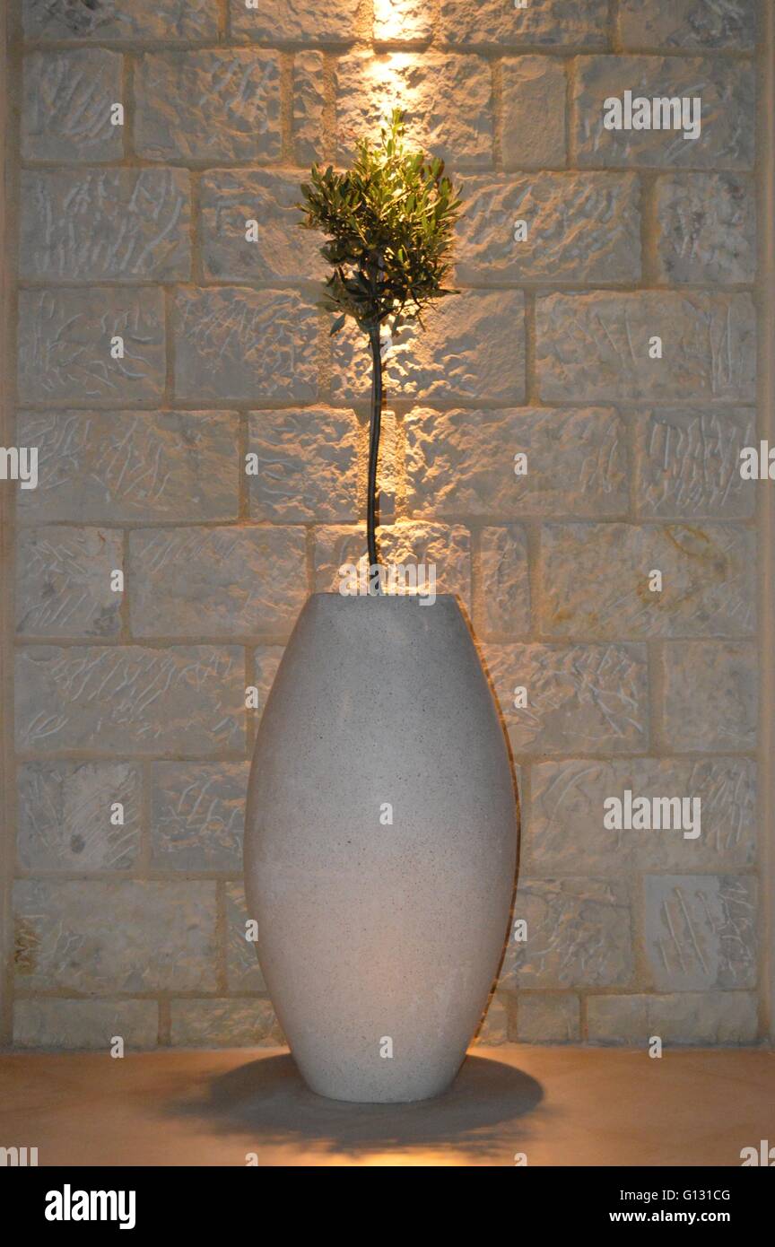 Große Vase von Stein Dekoration mit einer Pflanze unter einem Licht. Stockfoto