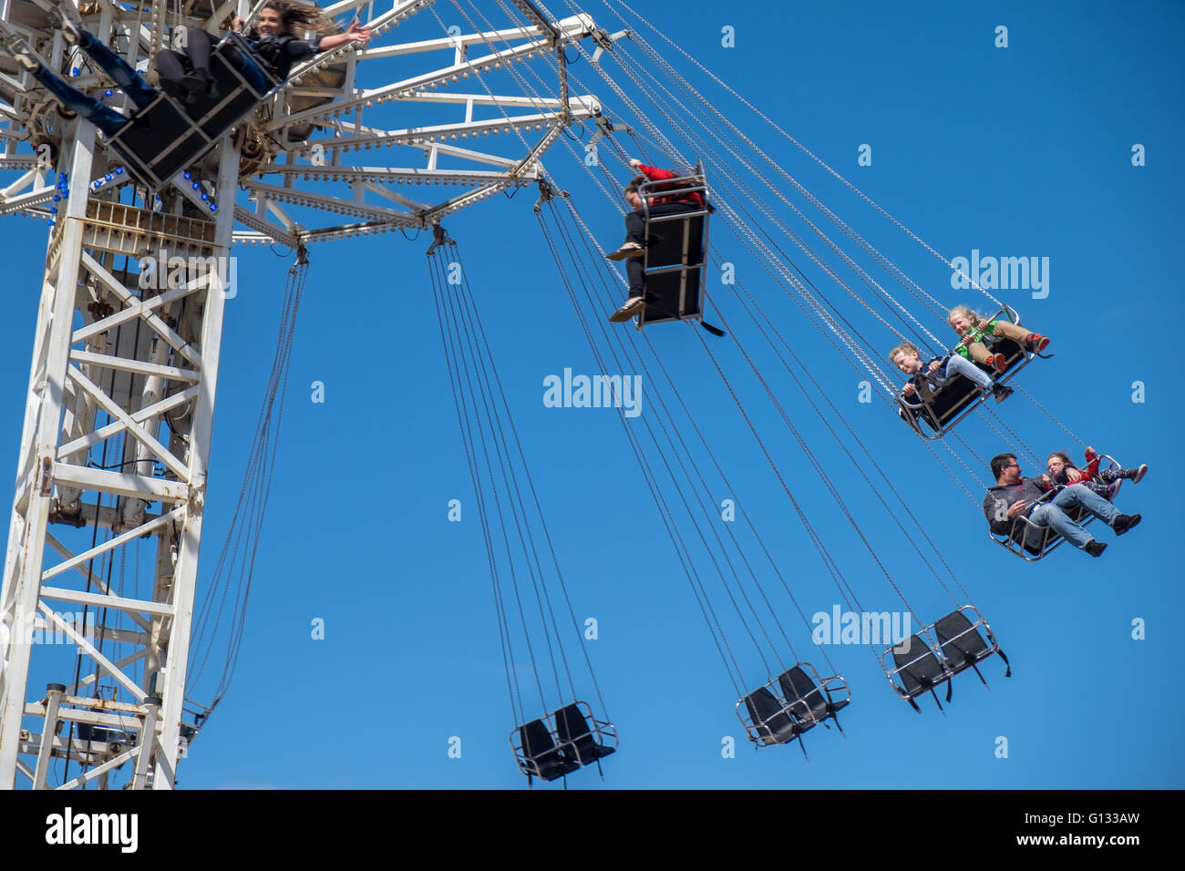 Kinder auf einer Schaukel fahren auf einer Kirmes in Morecambe Lancs UK. Stockfoto