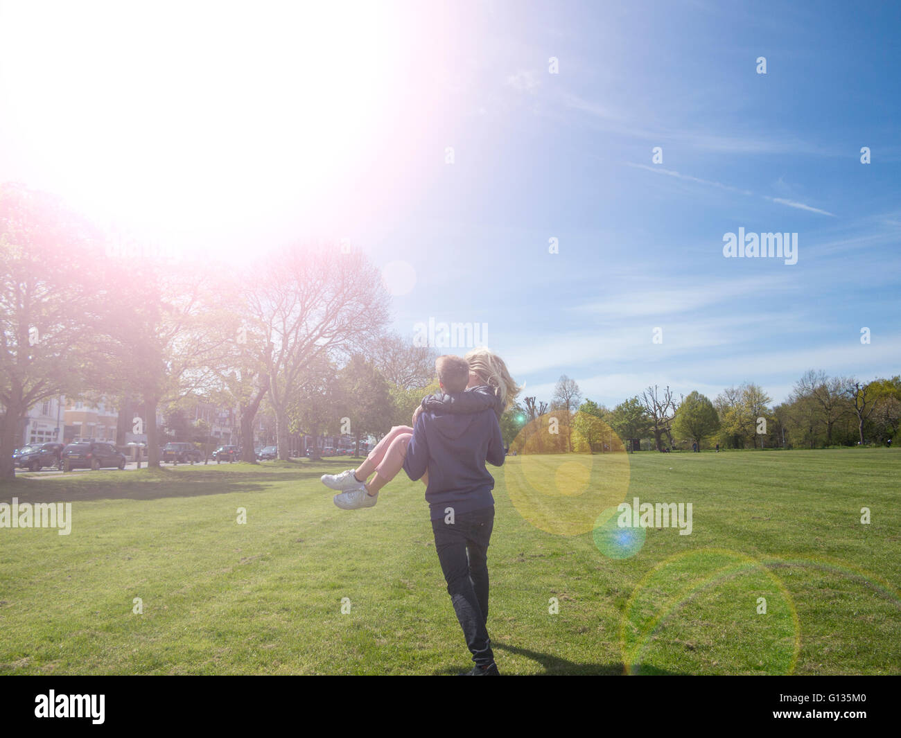 Ein Junge gibt einer Mädchen eine Huckepack in den Sommer Stockfoto