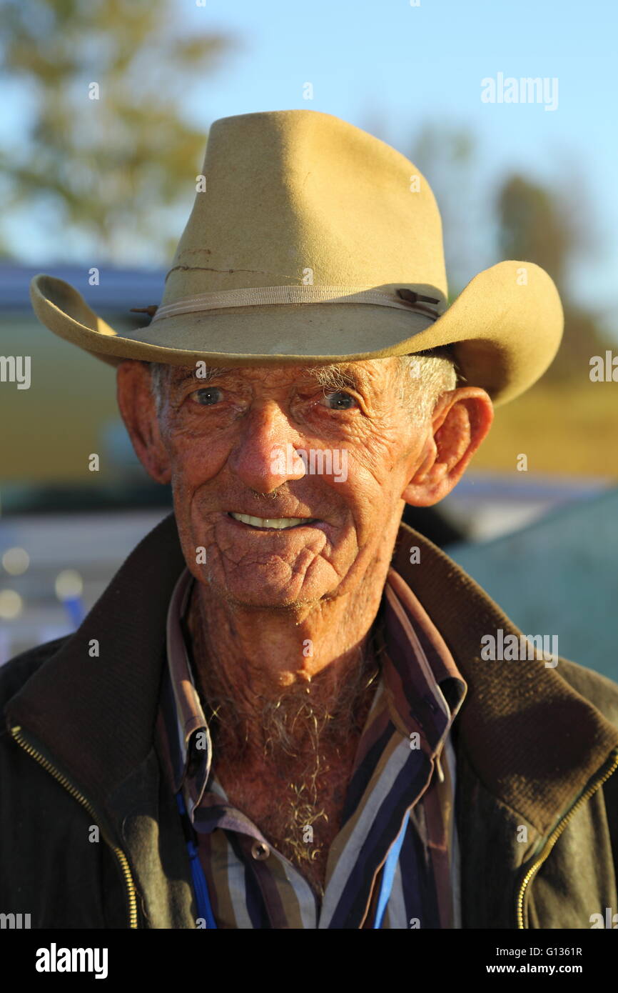 Ein runzligen 84 Jahre alte Cowboy mit Hut in die Kamera schaut. Stockfoto