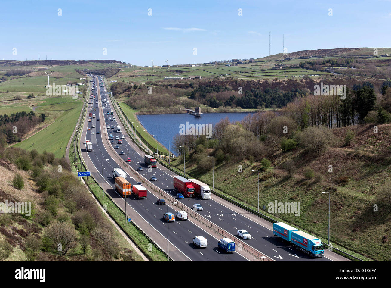 Verkehr geht Scammonden Reservoir auf der Autobahn M62 an einem sonnigen Tag, in der Nähe von Huddersfield, Yorkshire, England, am 4. Mai 2016 Stockfoto