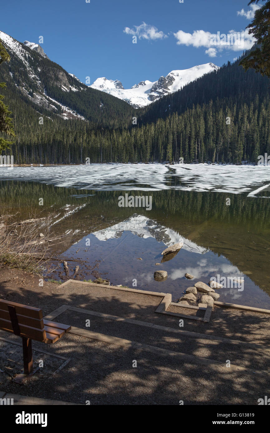 Schmelzender Schnee und Eis am Untersee Joffre aufzudecken Reflexionen auf Bäume, Berge und Gletscher Stockfoto