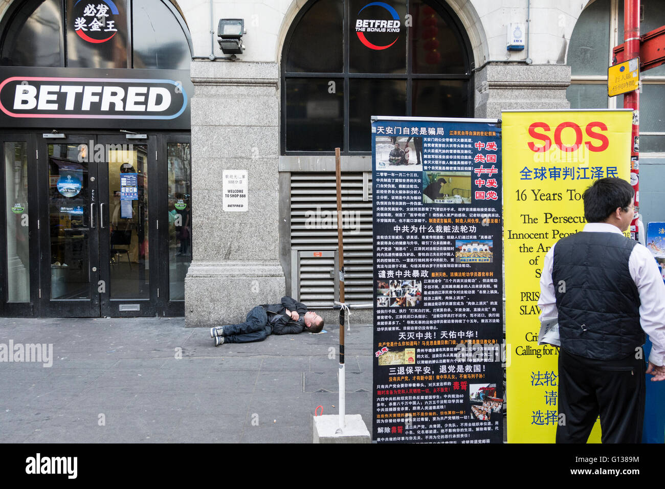 Einem Obdachlosen Mann schlafen draußen BETFRED auf Gerrard Street in Londons Chinatown Bereich. Stockfoto