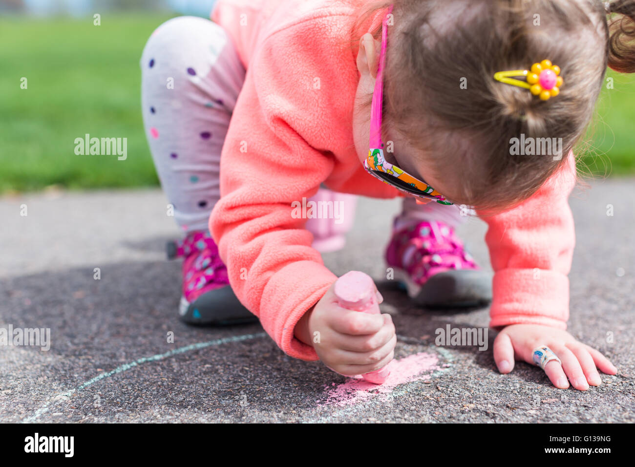 Zeichnen mit Kreide auf Kleinkind gepflastert Spaziergang in der Nähe von Spielplatz. Stockfoto