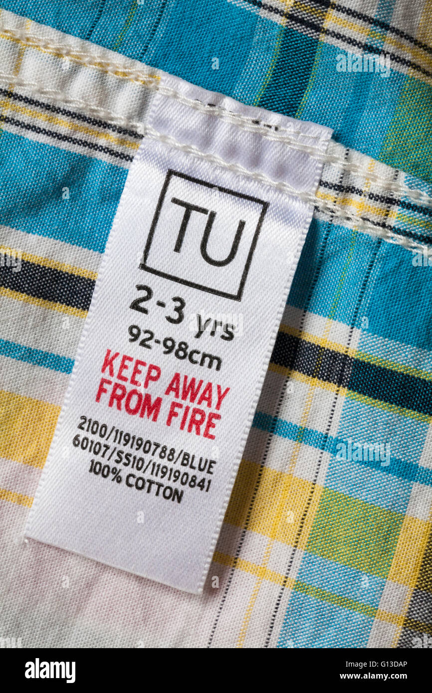 Etikett im Kleinkindershirt – TU 2-3 Jahre 92-98 cm vom Feuer fernhalten 100 % Baumwolle, TU-Kleidung in Sainsburys erhältlich Stockfoto