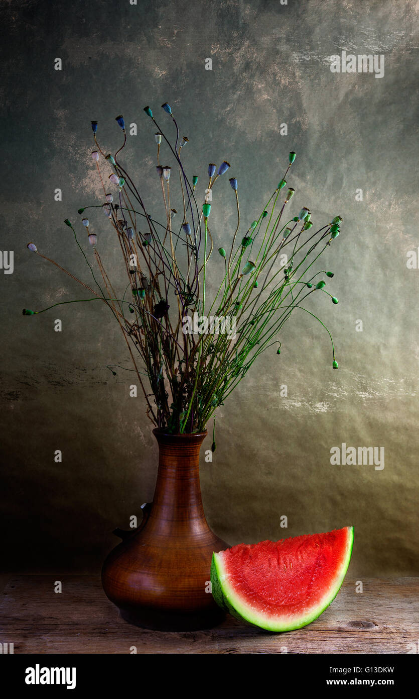 Stillleben mit Melone und verwelkte Mohn in vase Stockfoto