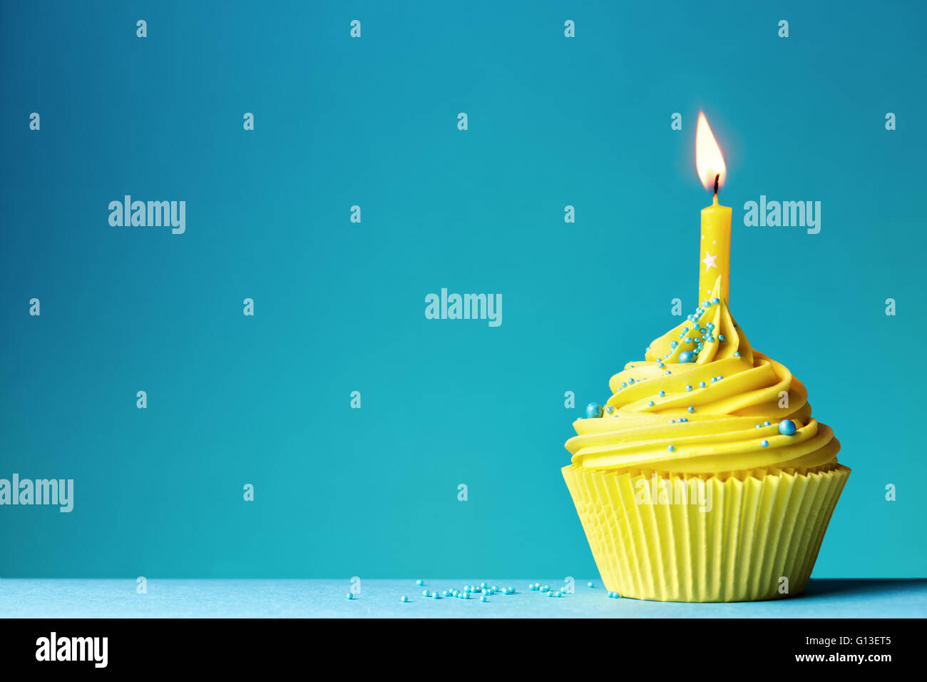 Gelbe Geburtstag Cupcake auf blau Stockfoto