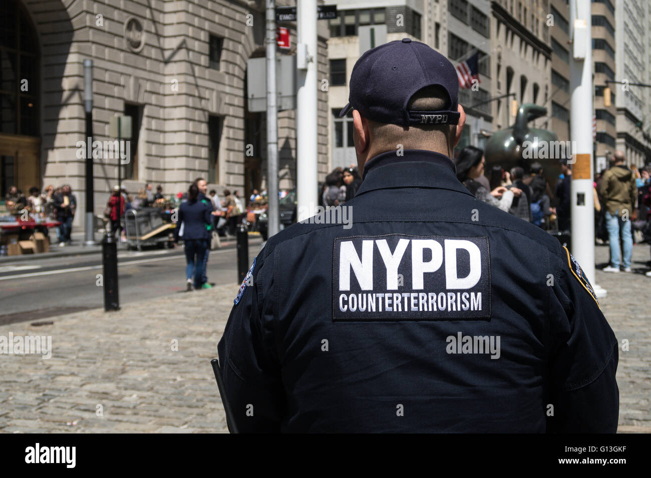 NYPD Counter Terror Offizier vom Dienst, laden Stier Skulptur in Bowling Green Park, New York Stockfoto